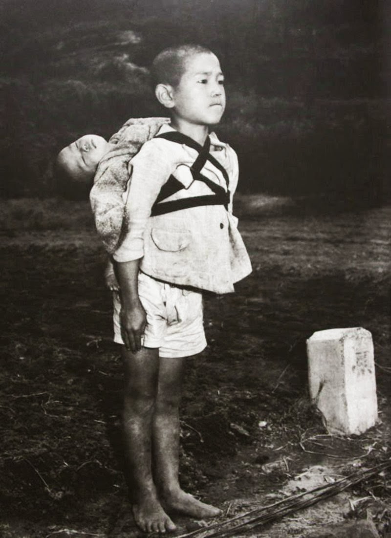 A+Japanese+boy+standing+at+attention+after+having+brought+his+dead+younger+brother+to+a+cremation+pyre,+1945.jpg
